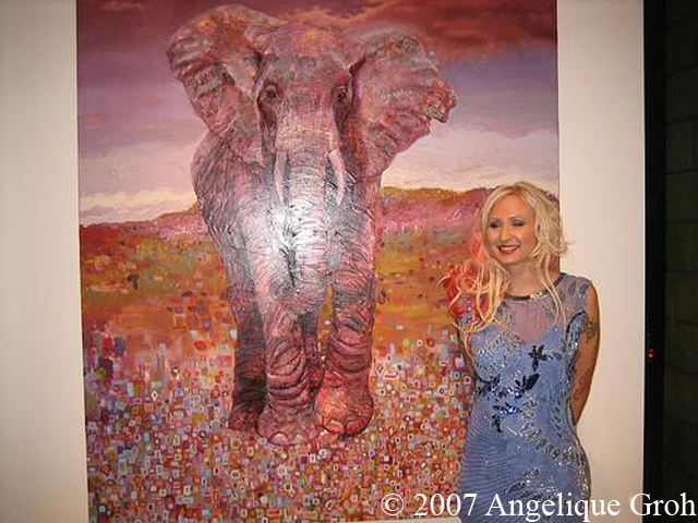 Natalia Fabia standing next to a painting of an elephant.